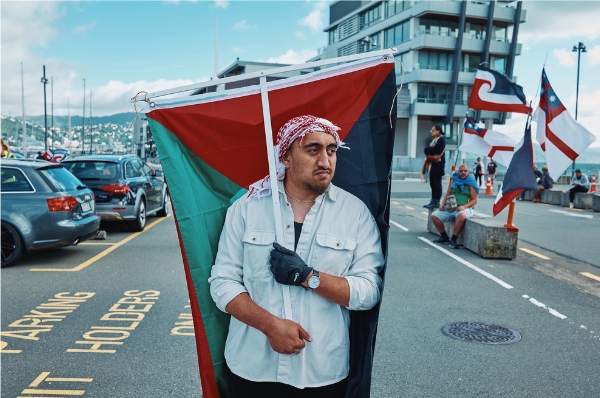 Man carrying a Palestinian flag during a Treaty of Waitangi protest march